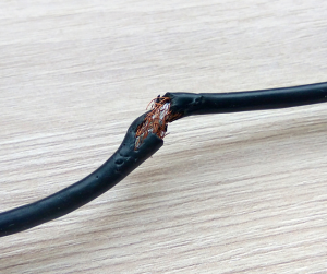 chewed up black cord with frayed wires exposed